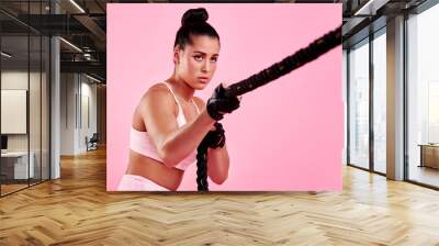 Muscle, battle rope and training with woman in studio for wellness, pull and challenge. Exercise, workout and health with person on pink background for fitness, performance and sports athlete Wall mural