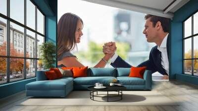 Office, business people and arm wrestle for challenge, competition and muscle strength on desk. Employees, man and woman with physical activity, endurance and shaking hands for game in workplace Wall mural