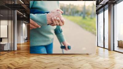 Park, walking stick and caregiver with senior woman for assisted living, support and care in nature. Retirement, help and hands of elderly person with disability for wellness, health and recovery Wall mural