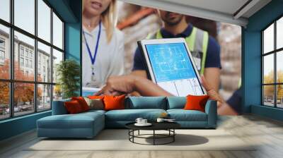 People, architect and tablet for blueprint in logistics warehouse for building, design or expansion. Contractor, point and scrum on app for floor plan, review or clipboard in factory for supply chain Wall mural