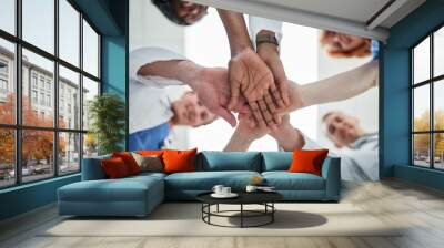 People, hands together and below with medical team for meeting, unity or motivation at hospital. Low angle or closeup of group piling or touching in collaboration, solidarity or mission at clinic Wall mural