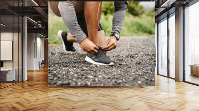 Person, hands and shoelace with fitness or running for exercise, health and wellbeing in outdoor. Road, sneakers and committed on workout or jog in morning for training, wellness and self care Wall mural