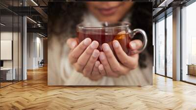 Person, hands and tea cup for winter drink with warm clothes for cozy weekend, relax or comfortable. Fingers, beverage and jersey for resting break or home peace for morning calm, health or herbal Wall mural