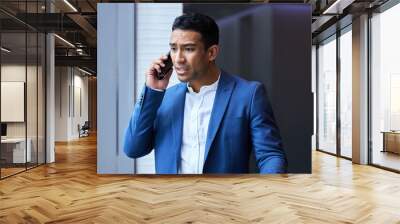 Phone call, stress and businessman by window for communication, anxiety and frustrated in office. Male manager, smartphone and upset in conversation for disappointed, inconvenience and company Wall mural