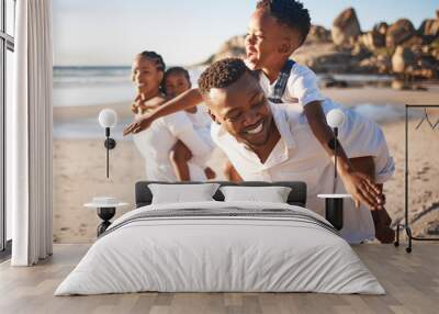 Piggyback, playing and black family at beach for fun on tropical vacation, travel or getaway. Smile, bonding and African children with parents by ocean or sea on holiday, adventure or weekend trip. Wall mural