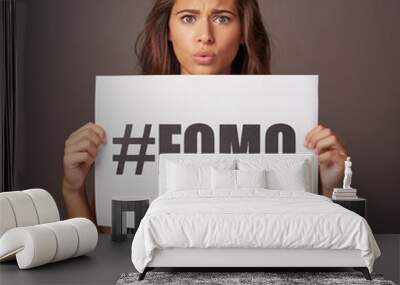 Poster, sign and portrait of woman in studio for information, text and advertising of insecurity. Paper, announcement and female person with anxiety on gray background for fomo, awareness and worry Wall mural