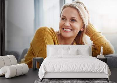 relaxing really lifts the spirits. shot of an attractive mature woman relaxing on the sofa at home. Wall mural