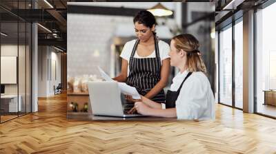 Restaurant, waitress or business owner with paperwork for planning budget, online review or admin. Laptop, manager and barista with teamwork in startup shop for report, stock taking and documents Wall mural