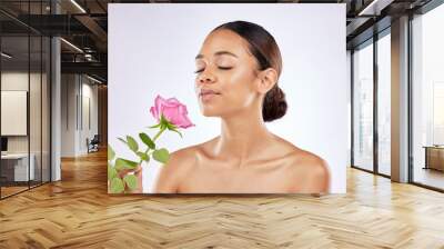 Rose, scent and woman in beauty with flower for healthy skincare on studio background. Floral, fragrance and girl smell perfume of plant blossom with natural glow on face from cosmetics in spring Wall mural