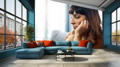 Stress, thinking and woman in home with depression, anxiety and broken heart or fail in living room. Reflection, sad and lonely girl with worry, regret decision and remember trauma or mistake on sofa Wall mural