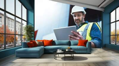 Tablet, engineer and man with helmet on construction site for development or building in city on project. Male person, tech and architecture as manager for progress in industrial, design and safety Wall mural