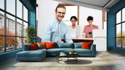 Tablet, happy and businessman in office for startup creative company for public relations career. Smile, team and male communications manager with digital technology for brand management in workplace Wall mural