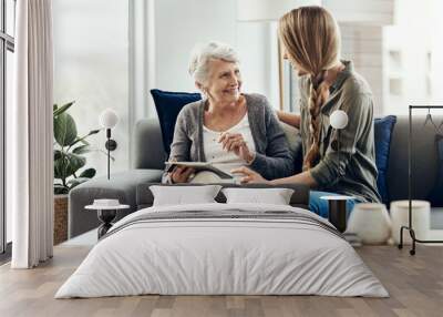 Tablet, living room and woman with senior mother in home for help with online blog, internet or connectivity. Bonding, sofa and elderly female person learning digital technology with daughter. Wall mural