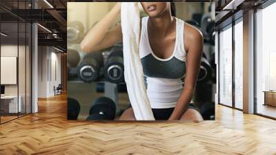 Towel, tired or woman sweating in gym exercise, workout or training with fatigue on break for recovery. Wipe, breathing or exhausted girl athlete thinking of resting on bench for health or wellness Wall mural