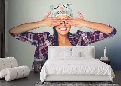 Woman, cover and face with fashion in studio for playful, personality or hide and seek game. Female person, happy and hands on eyes with animal beanie for funny, silly or surprise by white background Wall mural