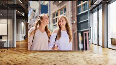 Women, happy and holiday with travel in city for outdoor adventure, urban and sightseeing together. Journey, smile and friends walking by buildings for weekend exploring, tourism or vacation in Italy Wall mural