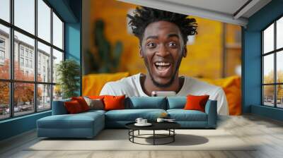 Beautiful black man excited surprise face expression, holding smartphone, white teeth, beautiful stylish hairstyle Wall mural