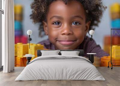 A child with a determined expression, building a tall tower with colorful blocks and focused on balancing each piece against a plain white background. Wall mural