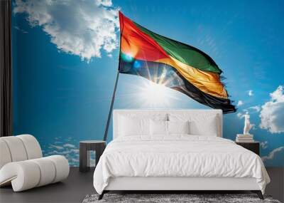 Mozambique flag fluttering against a bright, blue sky Wall mural