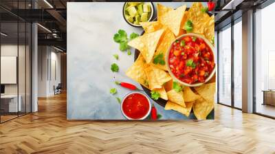 Mexican nachos chips with assorted sauces – guacamole, tomato salsa, chili, lime, and sour cream – on a stone table. Flat-lay, top view banner with copy space. Cinco de Mayo Snack. Wall mural