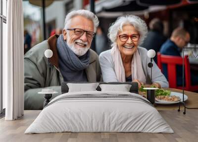 Couple of elderly seniors eat street food in a cafe and have fun Wall mural