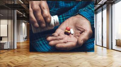 Many multi-colored pills in a Senior's hands Wall mural