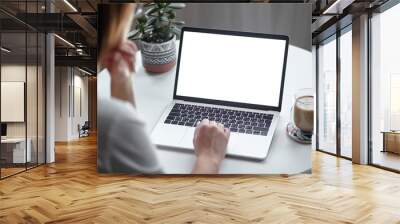 Mockup white screen laptop woman using computer while sitting at table at home, back view Wall mural