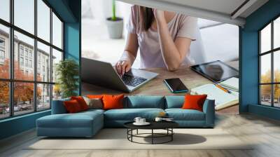 Young woman using laptop to work home, multiple devices Wall mural