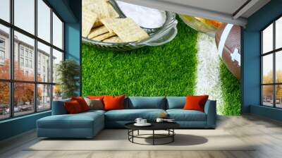 Snacks for watching a football game. Great for Super Bowl or Playoff themed projects. Pretzels, sausage, chips and dips with a football and a faux grass background Wall mural