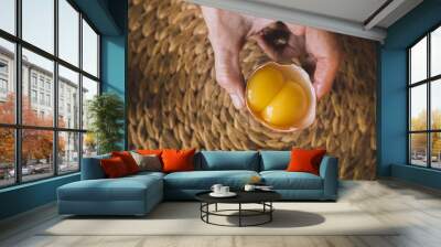 Person holding a raw egg with two yolks Wall mural