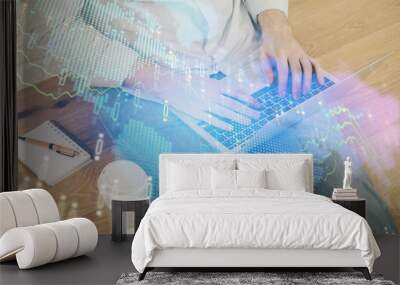 Double exposure of businessman's hands with laptop and stock market graph background. Concept of research and trading. Wall mural