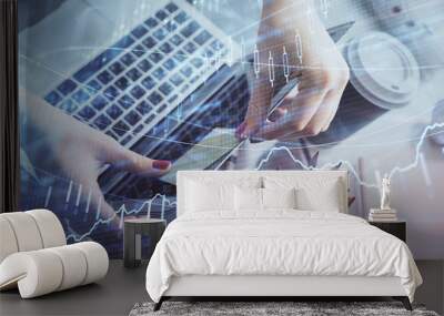 Double exposure of businesswoman hands typing on computer and financial graph hologram drawing. Stock market analysis concept. Wall mural