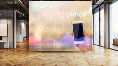 Double exposure of forex chart sketch hologram and woman holding and using a mobile device. Stock market concept. Wall mural