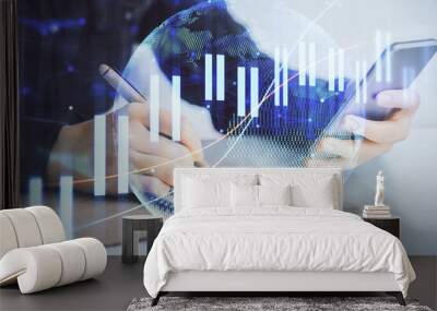 Double exposure of forex graph sketch hologram and woman holding and using a mobile device. Stock market concept. Wall mural