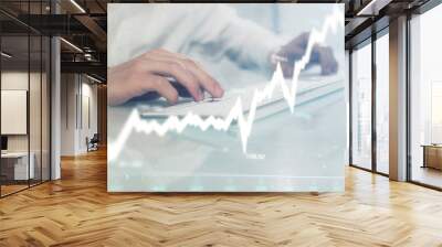 Double exposure of graph with man typing on computer in office on background. Concept of hard work. Closeup. Wall mural