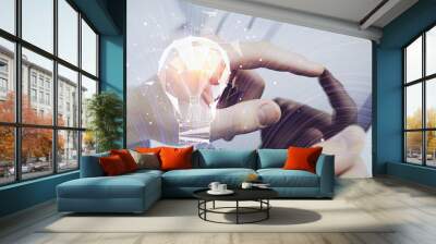 Double exposure of man's hands holding and using a digital device and bulb hologram drawing. Idea concept. Wall mural