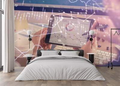 Double exposure of man's hands holding and using a phone and financial chart drawing. Market analysis concept. Wall mural