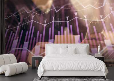 Double exposure of man's hands holding and using a phone and financial graph drawing. Analysis concept. Wall mural