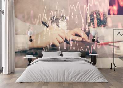 Double exposure of man's hands holding and using a phone and financial graph drawing. Analysis concept. Wall mural