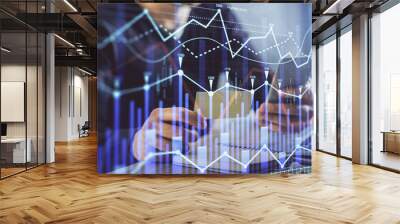 Double exposure of man's hands holding and using a phone and financial graph drawing. Analysis concept. Wall mural