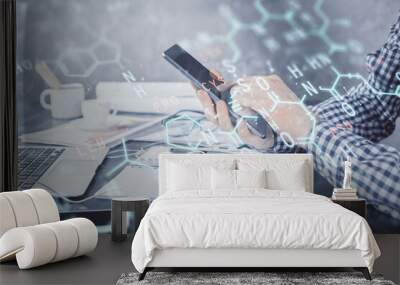 Double exposure of man's hands holding and using a phone and formulas drawing. Education concept. Wall mural