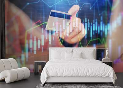 Double exposure of man hands holding a credit card and Forex graph drawing. Stock trading and digital fintech in Internet E-commerce concept. Wall mural