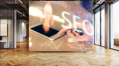 Double exposure of SEO sketch hologram and woman holding and using a mobile device. Wall mural