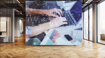 Double exposure of stock graph with businessman typing on computer in office on background. Concept of hard work. Wall mural