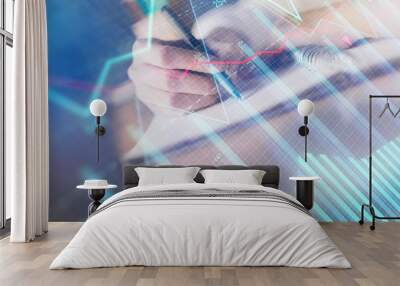 Financial forex graph displayed on hands taking notes background. Concept of research. Double exposure Wall mural