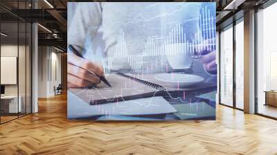 Forex chart hologram on hand taking notes background. Concept of analysis. Double exposure Wall mural