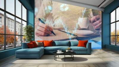 Forex chart hologram on hand taking notes background. Concept of analysis. Double exposure Wall mural