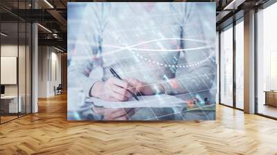 Hand taking notes in notepad. Forex chart holograms in front. Concept of research. Double exposure Wall mural