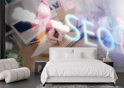 Multi exposure of woman's hands making notes with SEO icon. Concept of Search engine optimization Wall mural