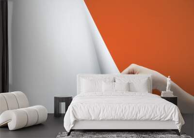 Woman hand turning orange page Wall mural